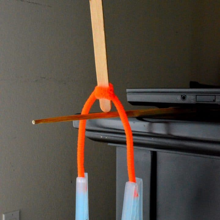 center of gravity science experiment: balance the tip of the craft stick on top of the chopstick