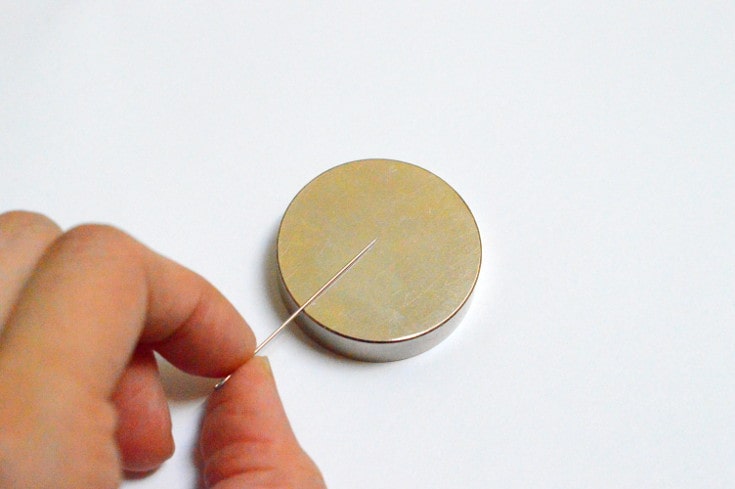 Rub a needle on the magnet to make a compass
