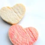 2 heart shaped plastic made with milk and vinegar, one ivory and one pink in color