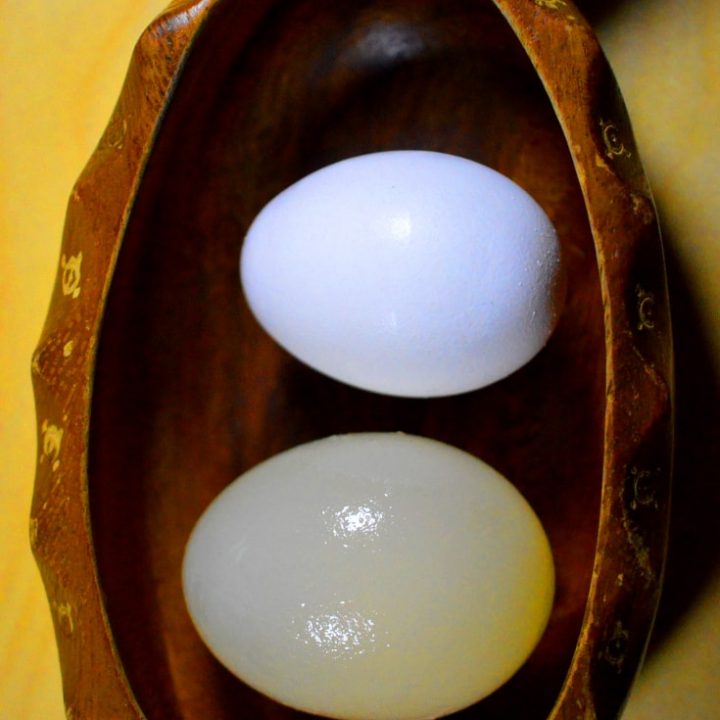 two raw eggs, one before experiment and one after experiment