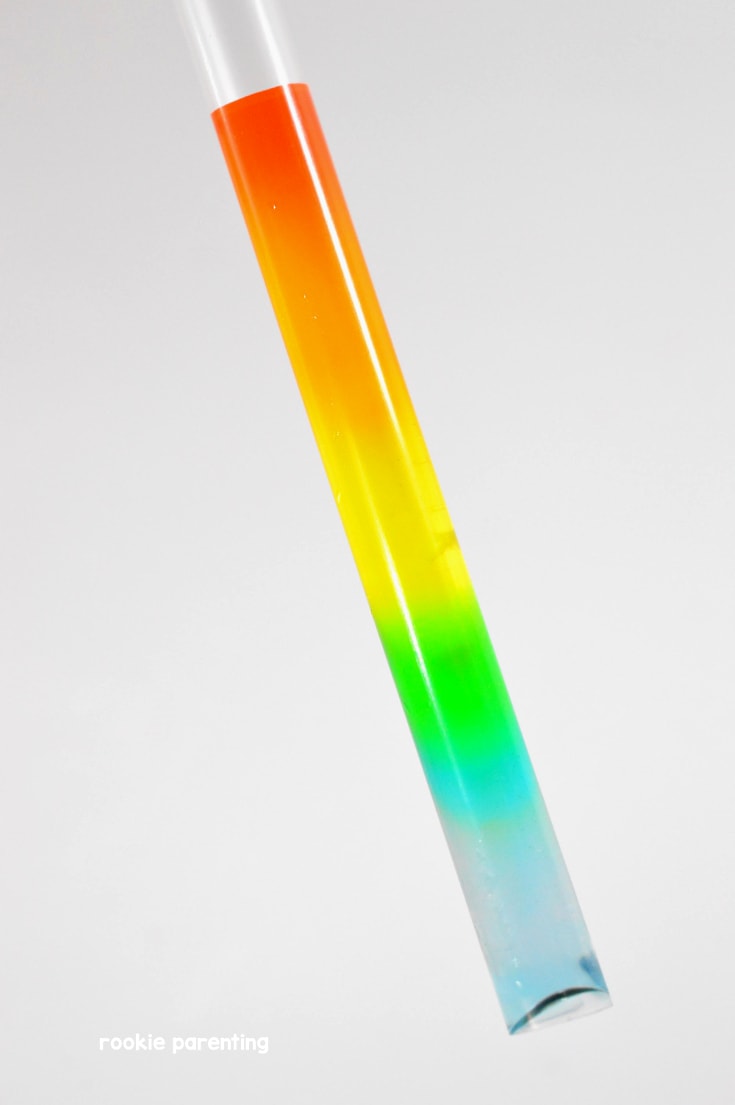 water with rainbow color inside a straw