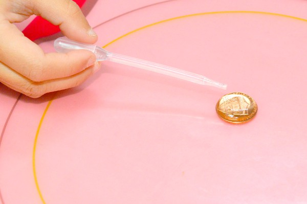 Using a dropper, drop water onto the penny